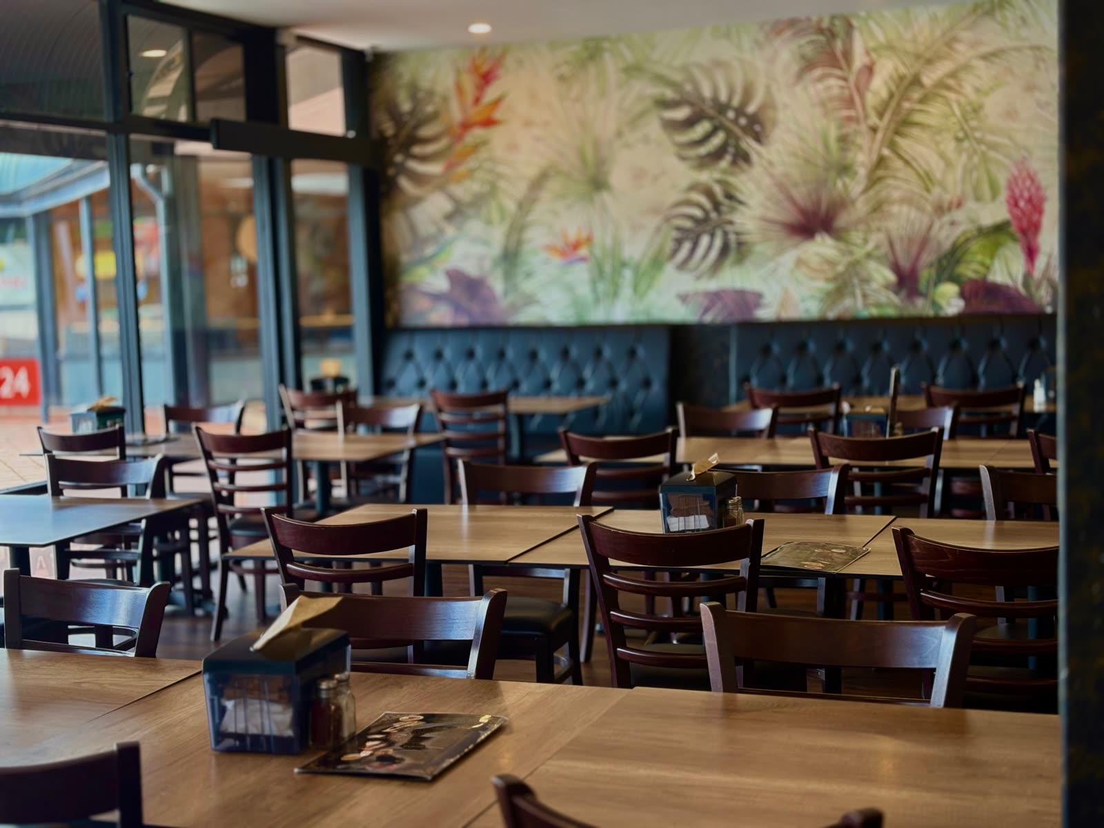 Kabul Café dining room with its tropical mural and tufted booth seating